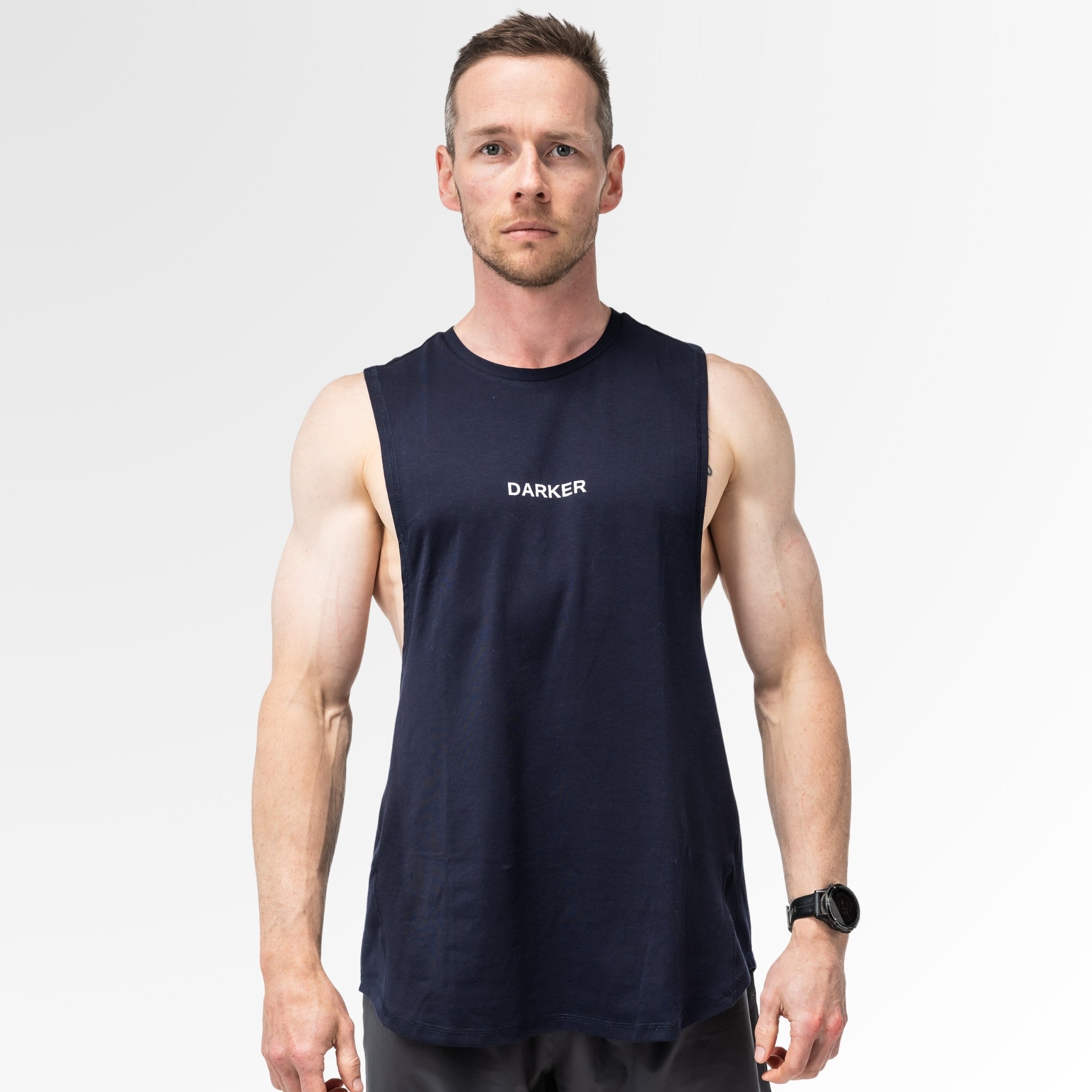 Man wearing a navy tank with 'DARKER' logo on a white background