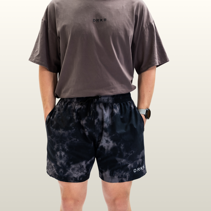 Man wearing the midnight camo Endure 7 inch Shorts with a storm grey tee, front view