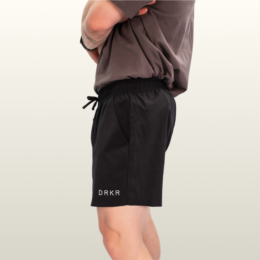 Man wearing the black Endure 7 inch Shorts, side view