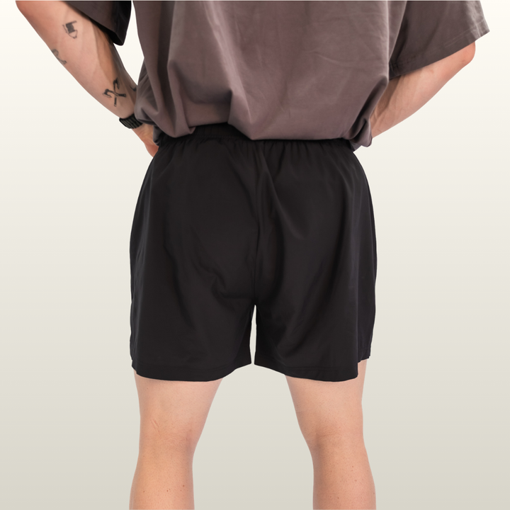 Man wearing the black Endure 7 inch Shorts, back view