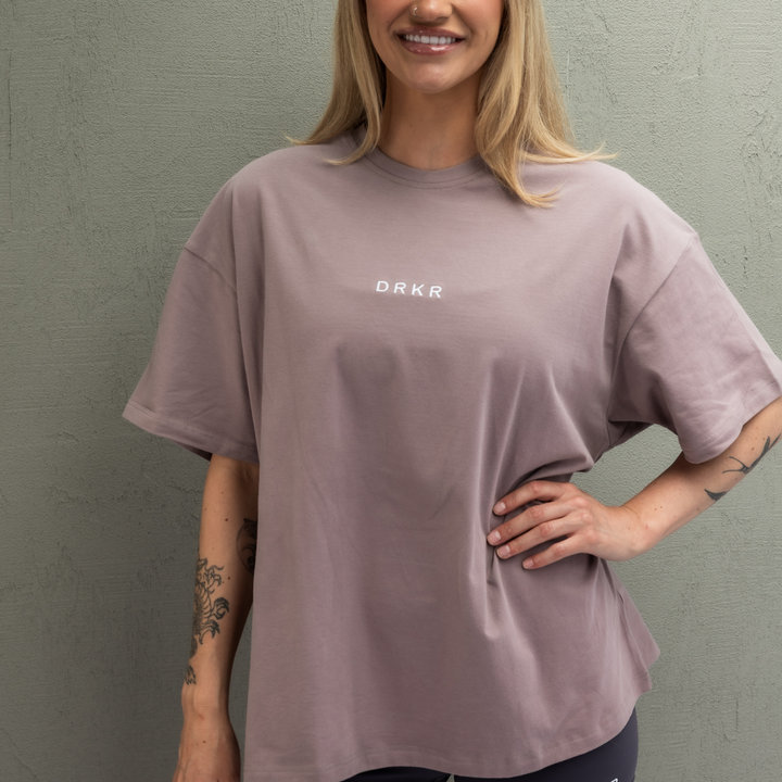 Smiling woman wearing the dusty pink Endure Oversized Tee with hands on hips