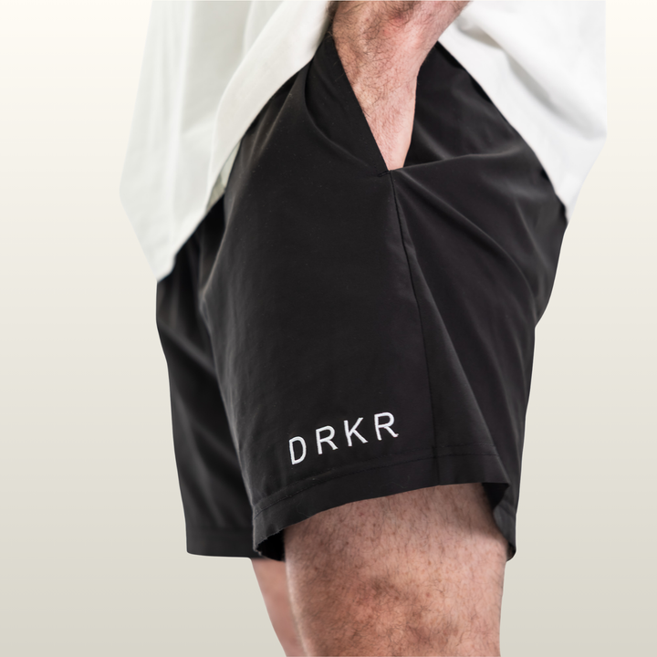 Close-up of the side pocket and DRKR leg logo on the black Endure 7 inch Shorts