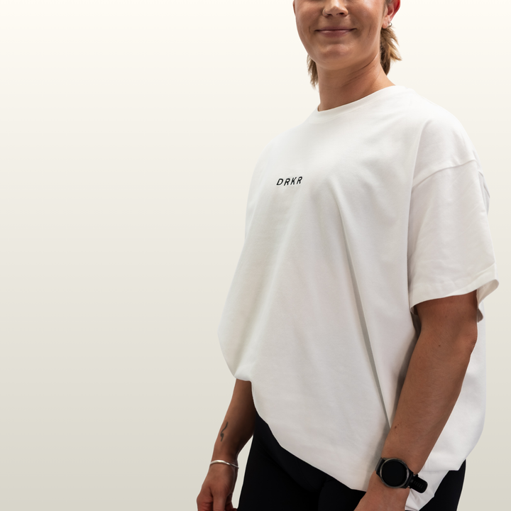 Woman wearing the white Endure Oversized Tee, three-quarter view