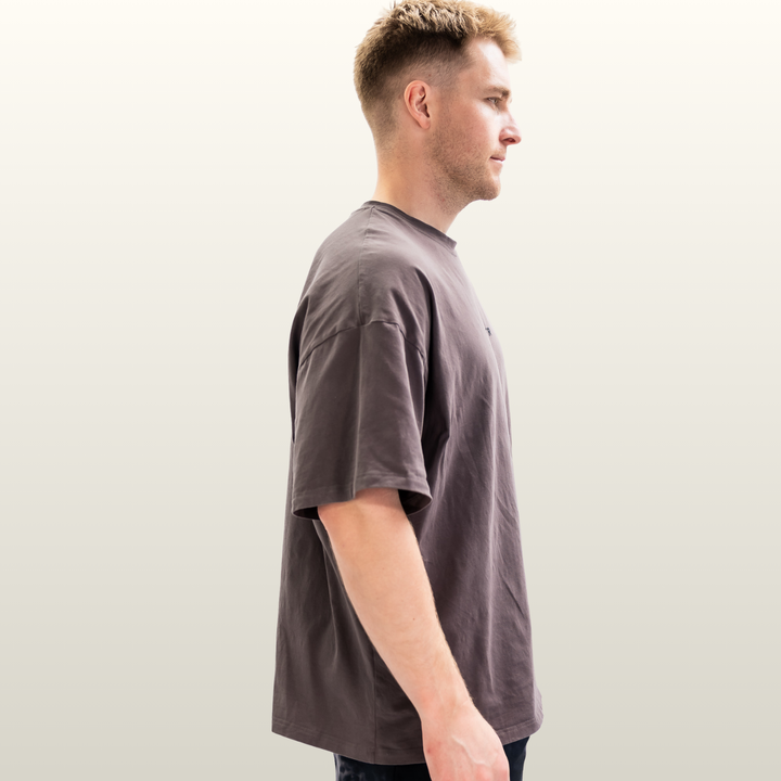 Man wearing the storm grey Endure Oversized Tee, side profile view