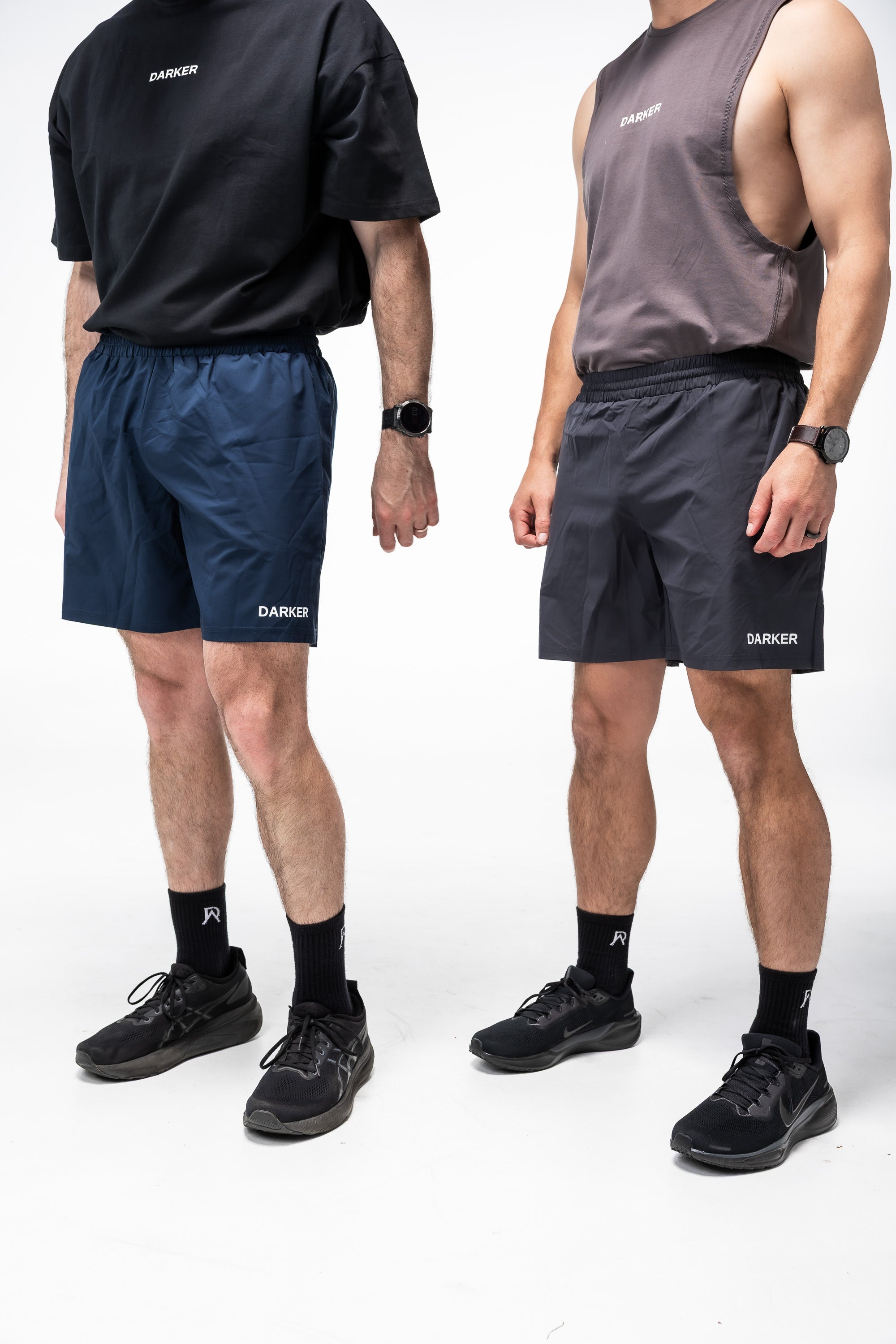 Two people wearing navy and gray shorts with a brand logo on a white background