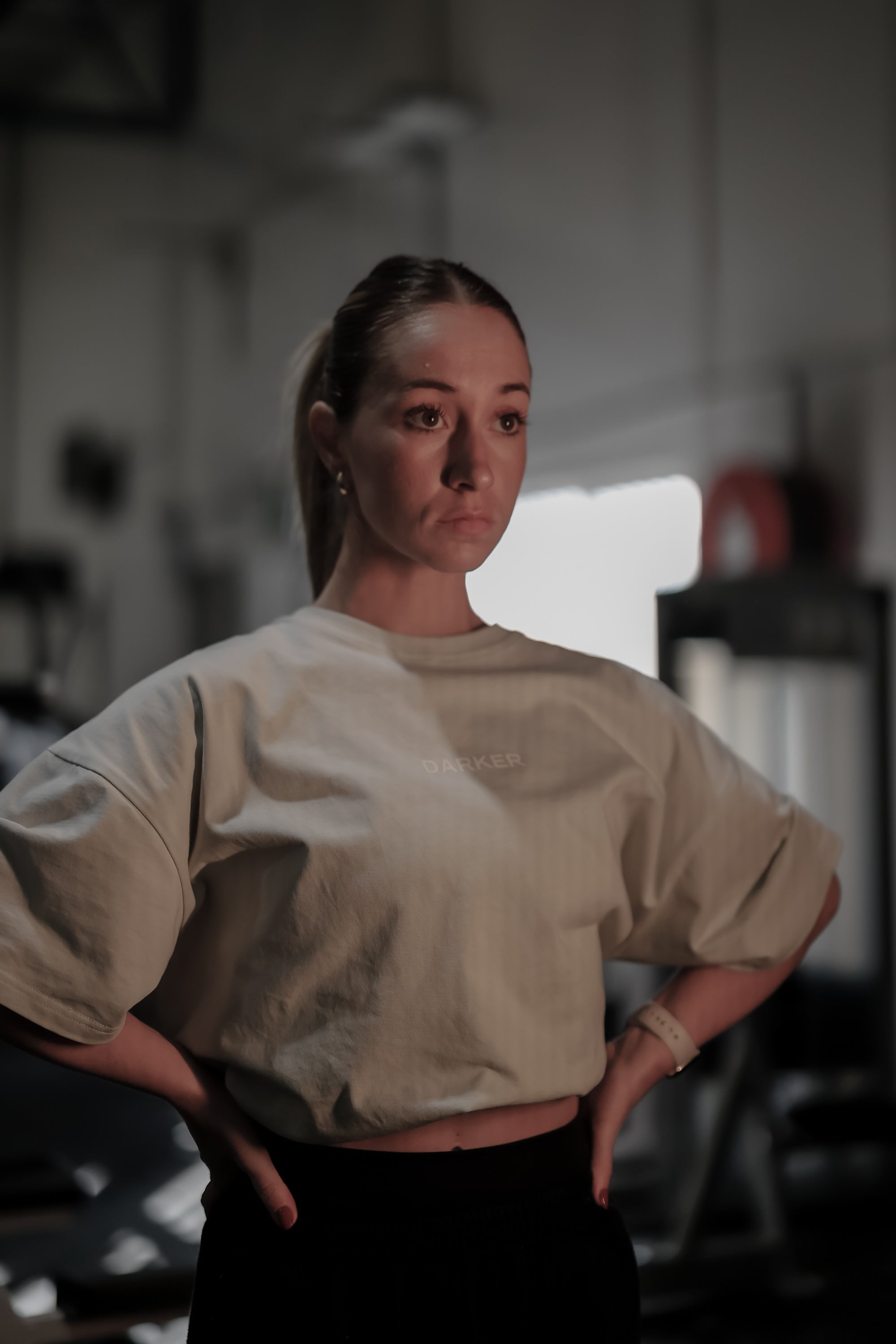 Person wearing a light steel blue oversized shirt in a gym setting