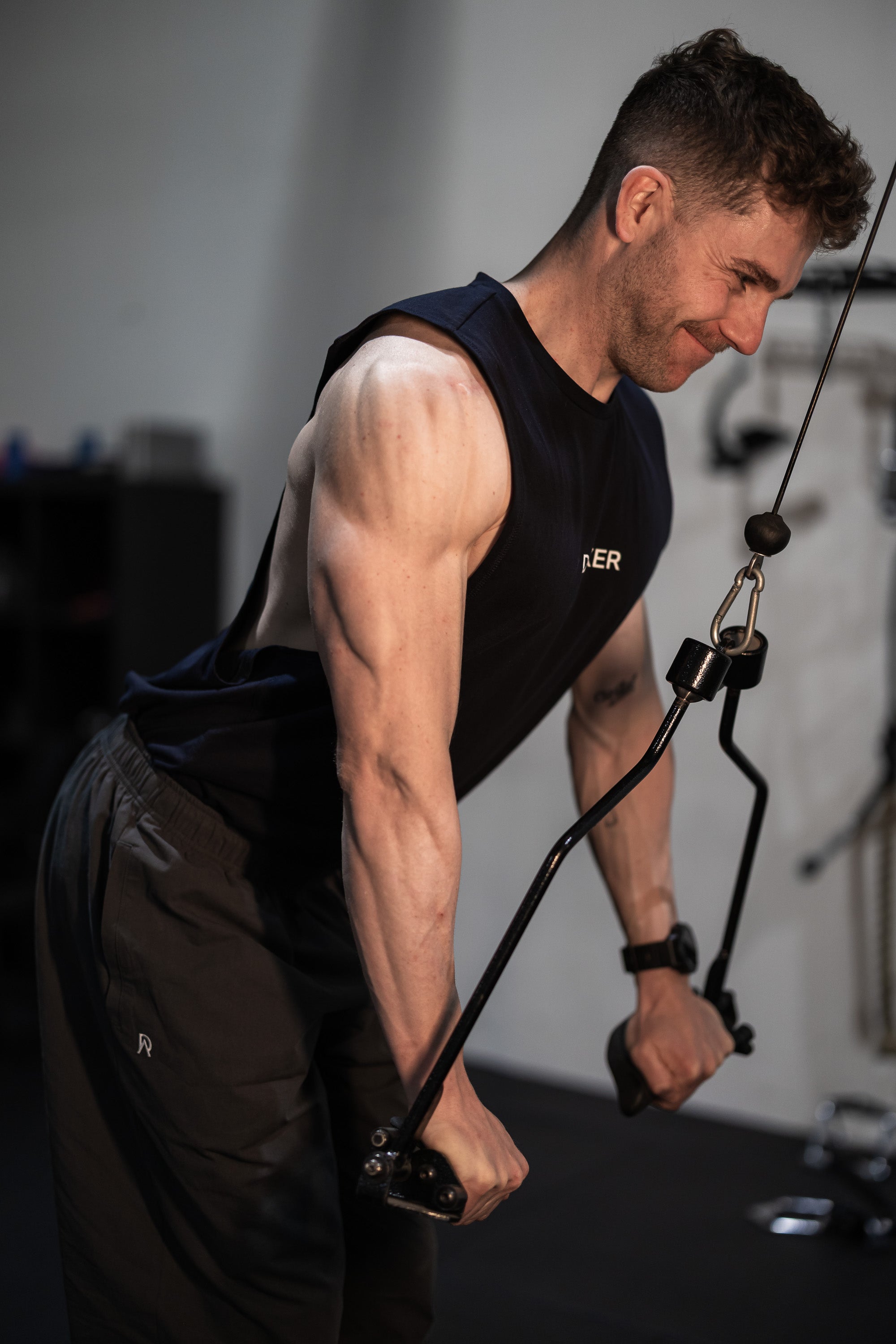 Man exercising with cables in a gym setting