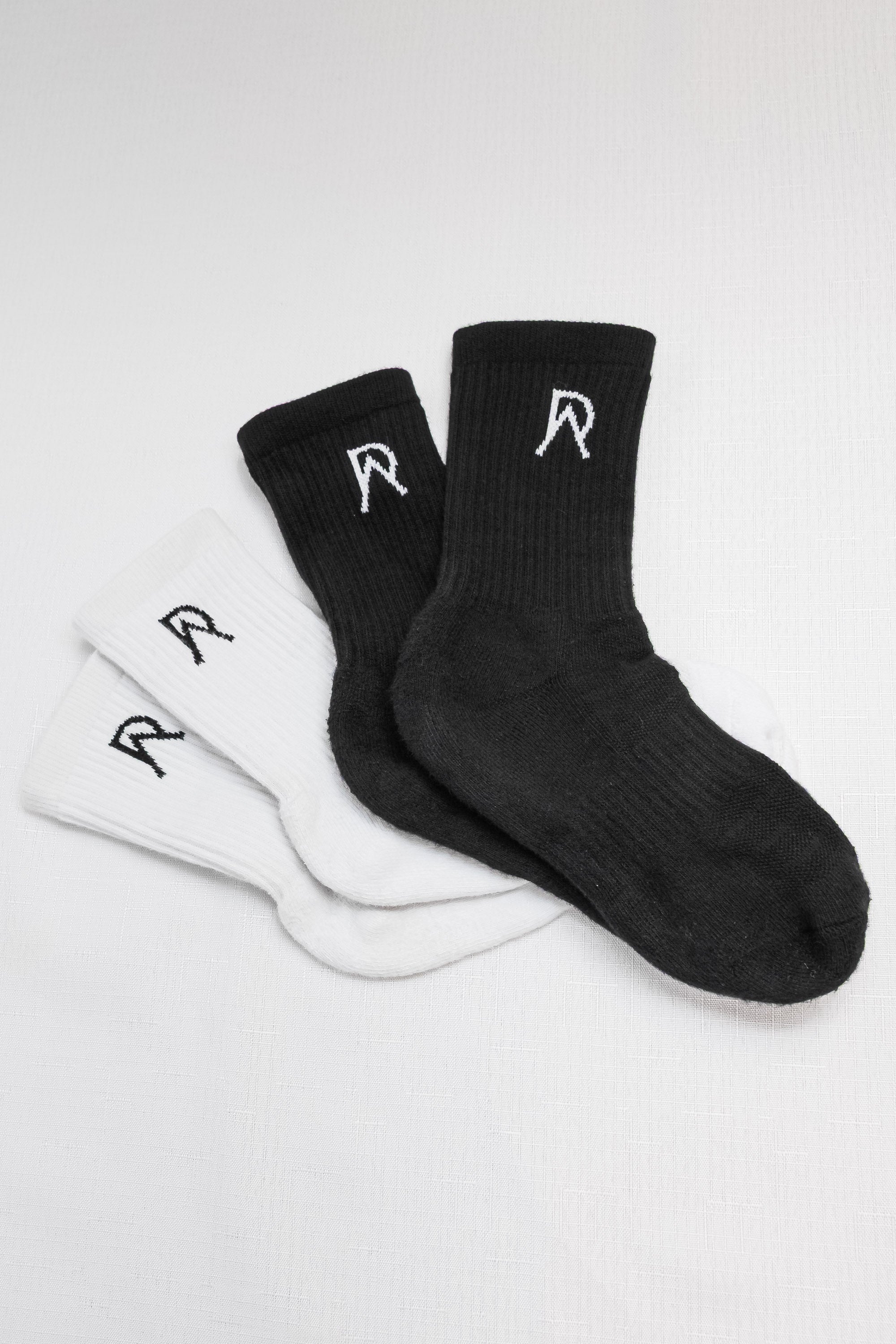 Two pairs of black and white socks with a logo on a light gray background