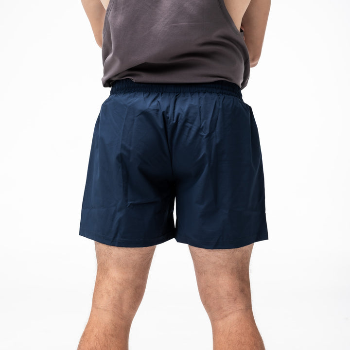Person wearing DARKER navy shorts on a white background