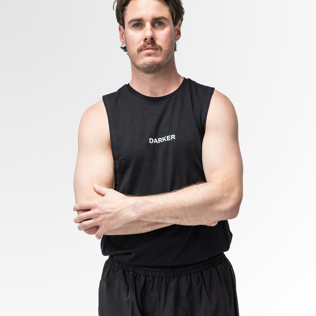 Man wearing a black sleeveless shirt with 'DARKER' logo on a white background