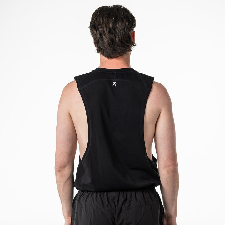 Person wearing a black sleeveless shirt with a logo on the back against a white background