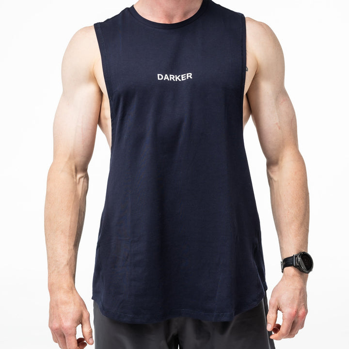Person wearing a navy tank with 'DARKER' logo on a white background