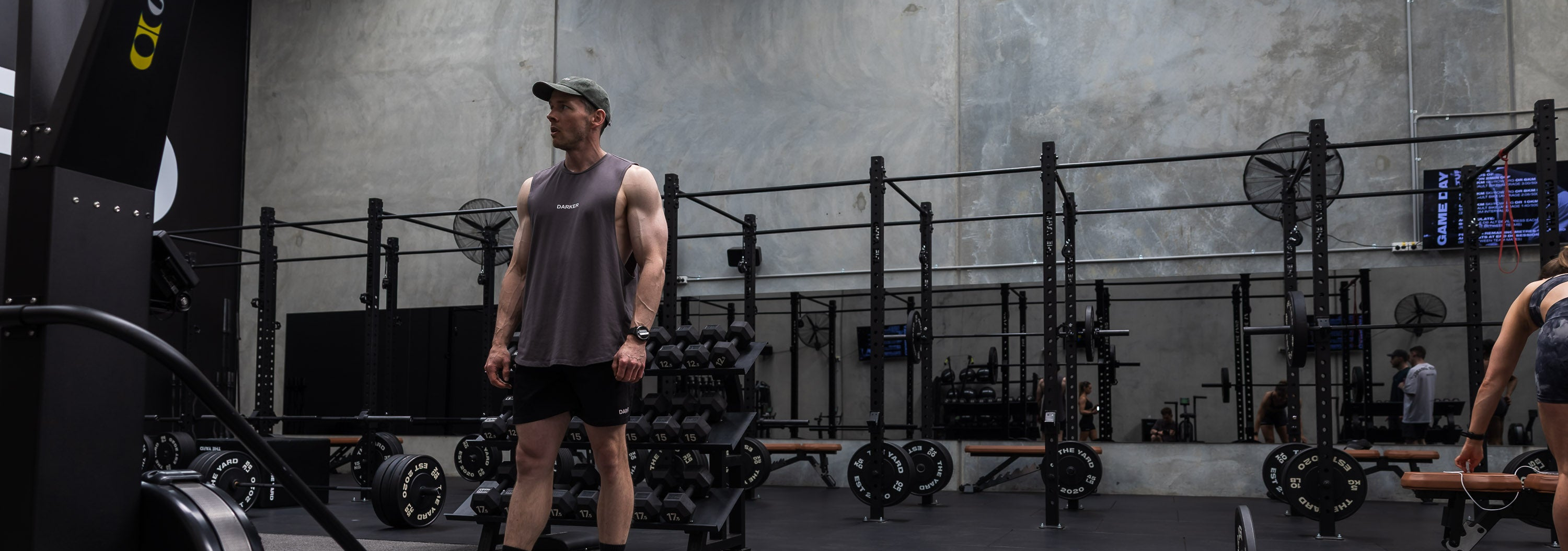 Person standing in a gym with exercise equipment in the background
